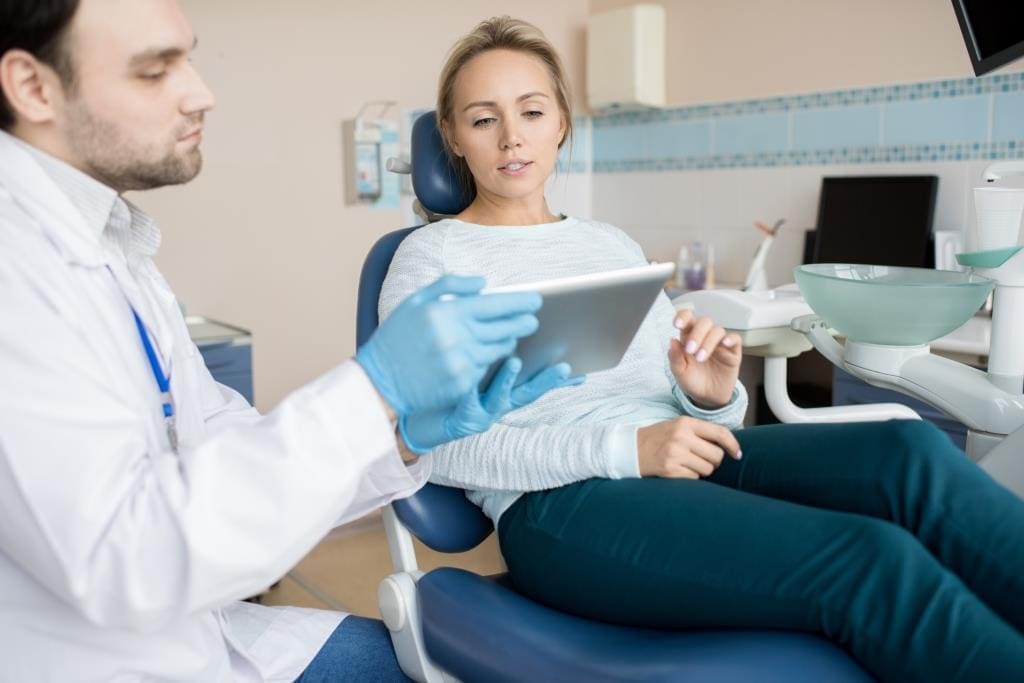 Melrose dental clinic | Dentist showing patient a dental issue,