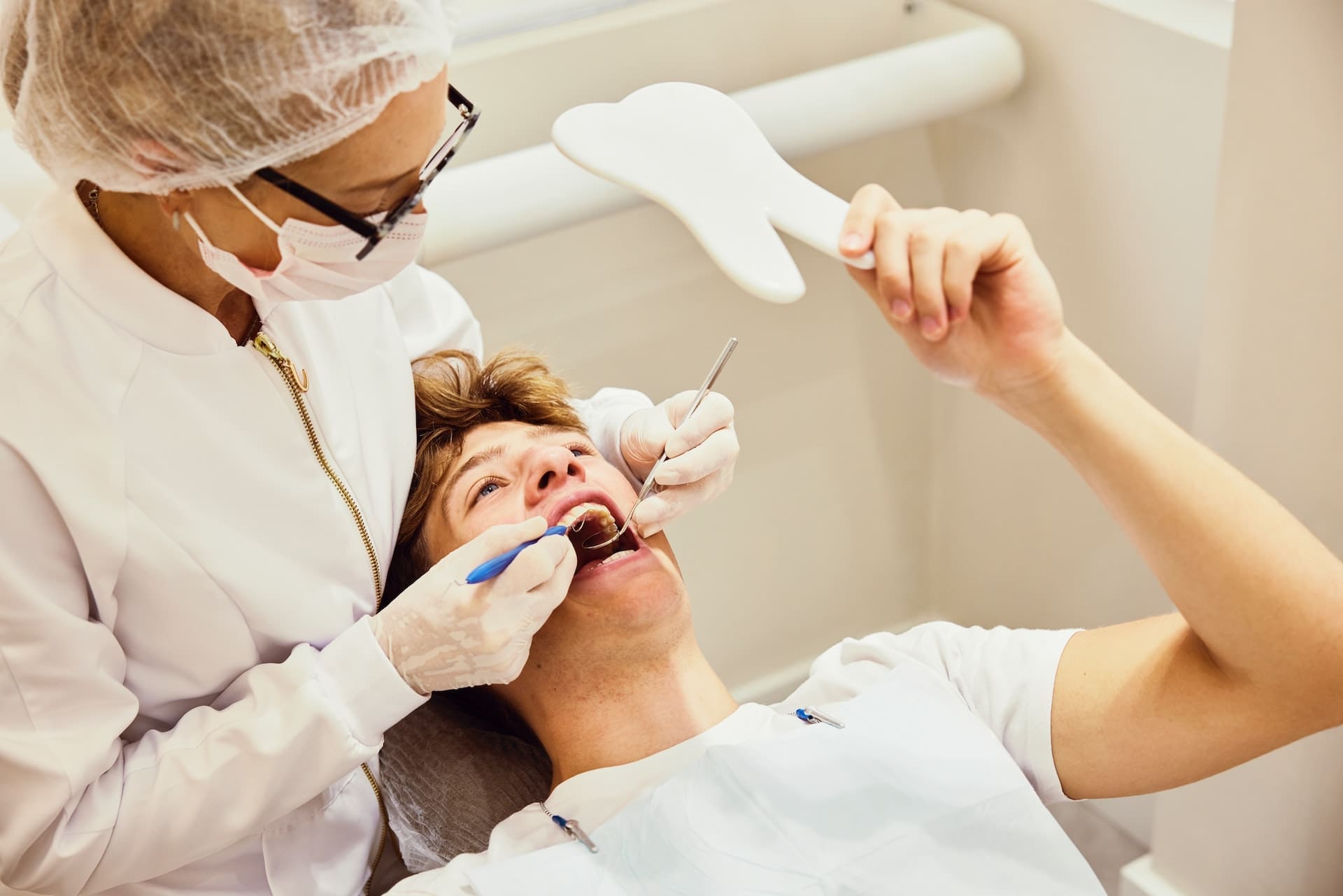 Dental patient looking at their smile in mirror after getting dental crown