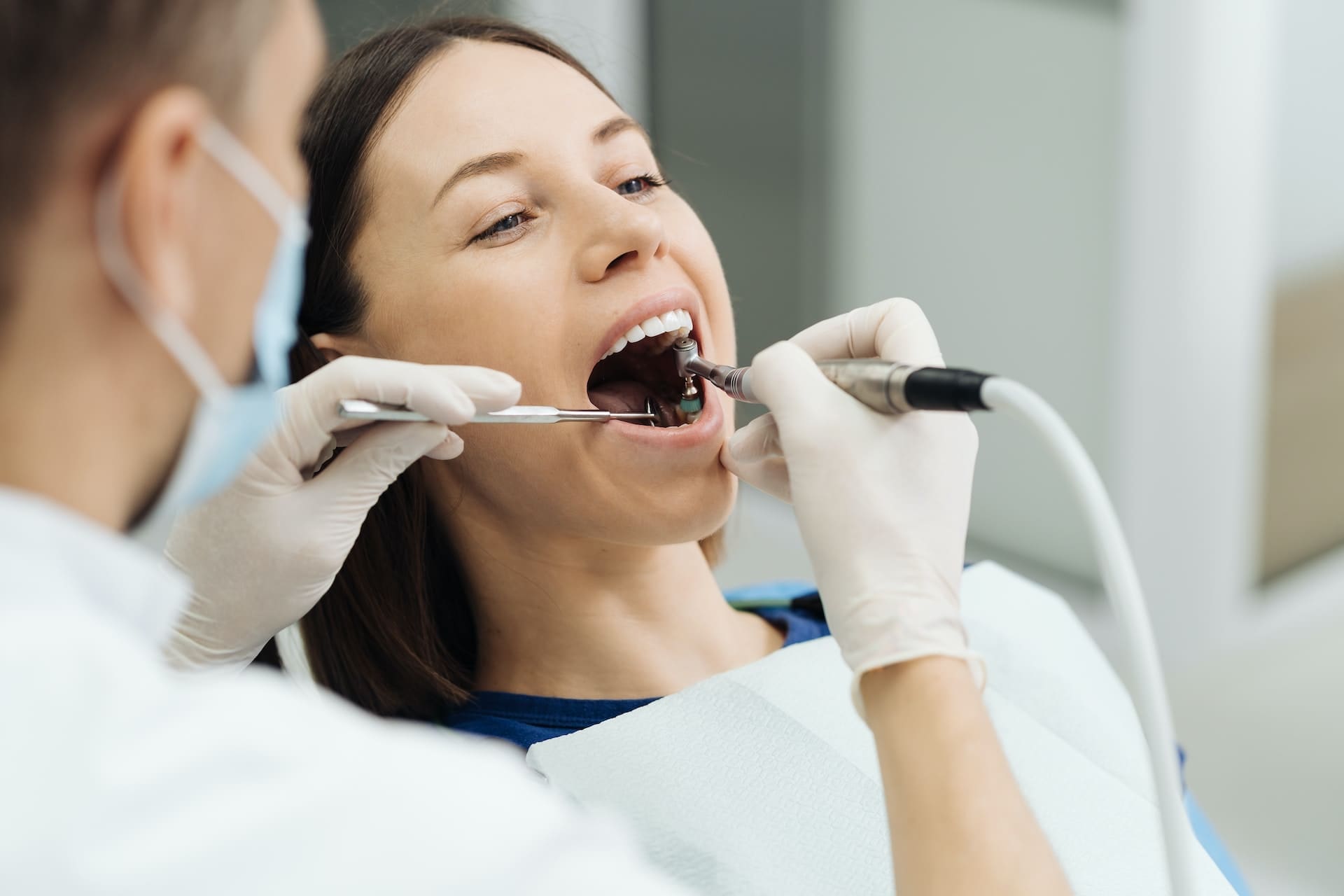 Woman in dental chair receiving teeth whitening treatment