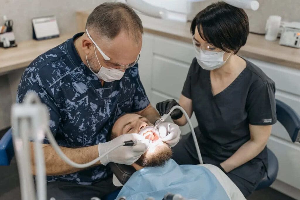 Dentist and assistant taking digital dental impressions of a patients teeth