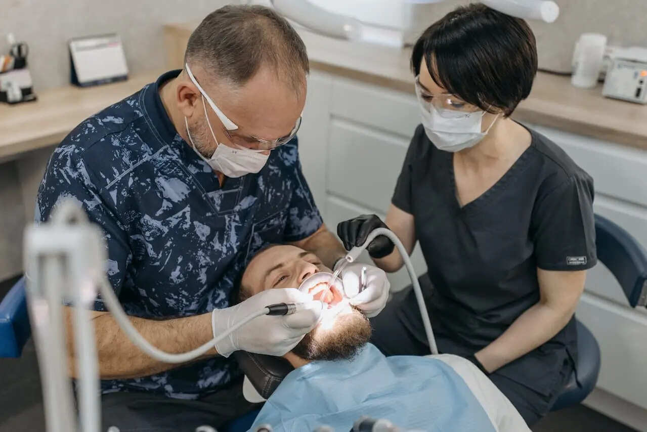 Dentist and assistant taking digital dental impressions of a patients teeth