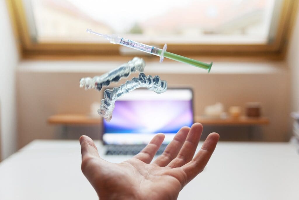 Invisalign clear aligner floating above a hand