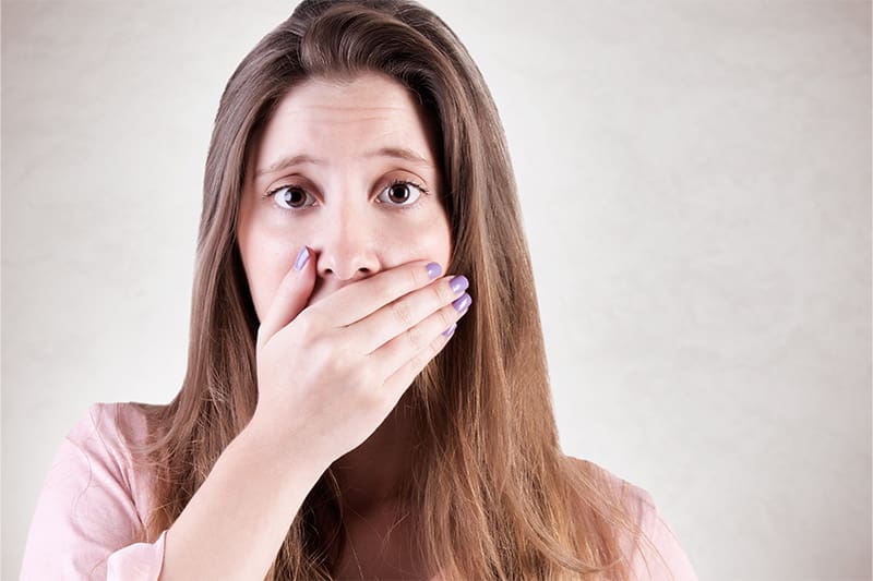 Concerned woman covering her mouth