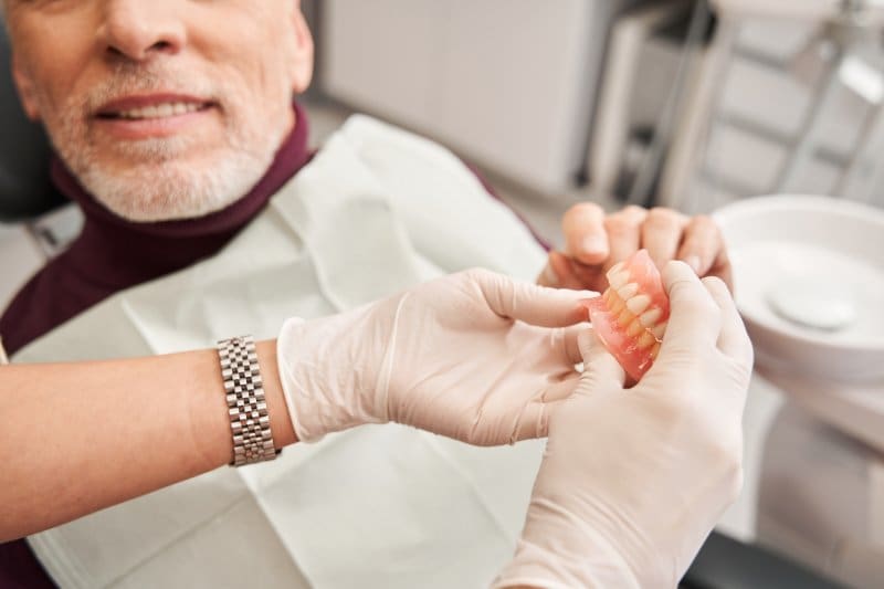 Dentist examining a patient’s dentures