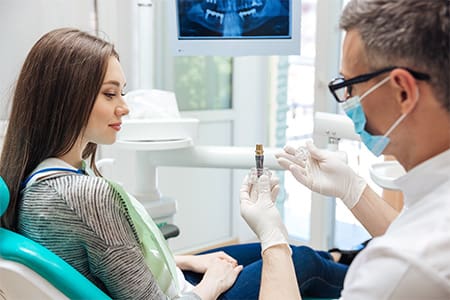 A dentist explaining dental implant treatment to his patient