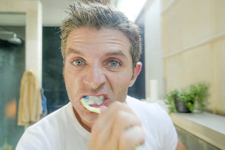 Man brushes teeth