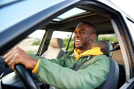 Man smiles as he drives