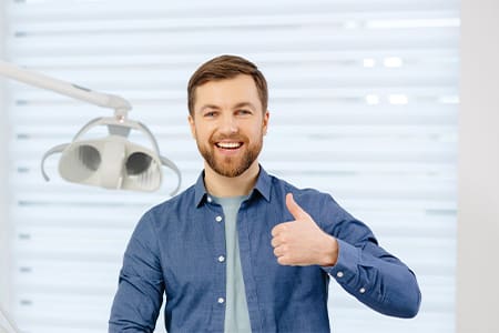 Bearded male dental patient giving thumbs up