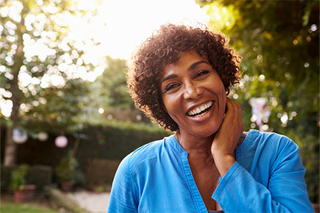 Woman in blue blouse smiling confidently.