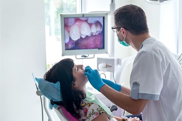 dentist-examining-patients-smile-v1 Dentist examining patient’s smile