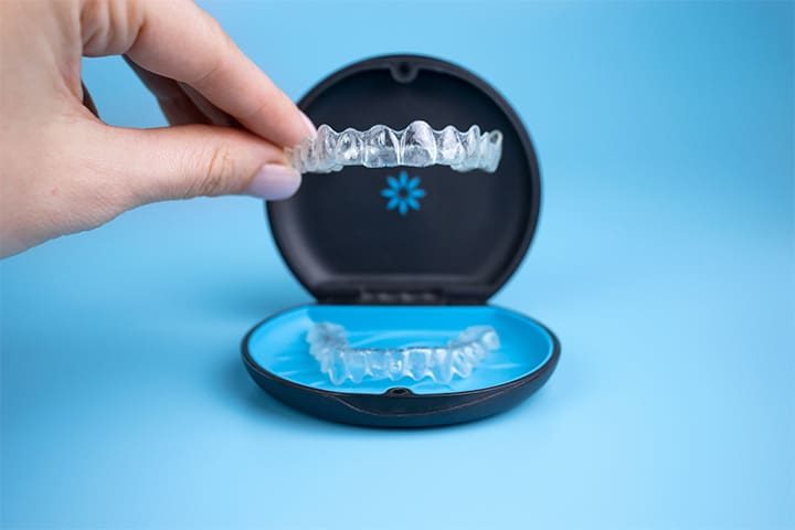 Patient putting clear aligner in case
