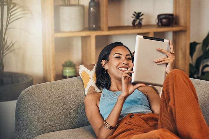 woman-relaxing-with-tablet-on-couch-v1.jpg Woman relaxing with tablet on couch